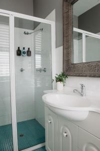 a bathroom with a sink and a shower with a mirror at The Westbury Dubbo in Dubbo