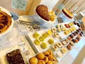 una vitrina con diferentes tipos de pasteles y repostería en Hotel Monica en Rímini