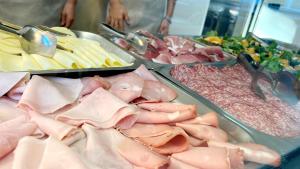 un buffet di carni e altri prodotti alimentari su vassoi di Hotel Monica a Rimini