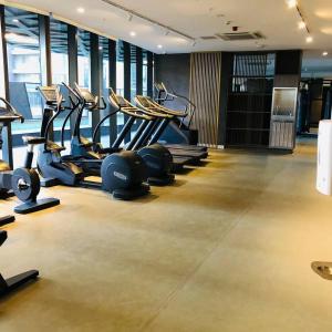 a gym with a row of treadmills and machines at Sky Apartment - Realm Adelaide in Adelaide