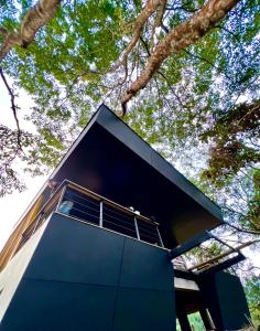 Casa moderna con fachada azul y árboles en Itawa Luxury Glamping & Ecoparque turísticos, en Villavicencio