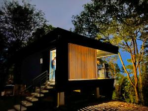una pequeña casa negra con una persona de pie en la ventana en Itawa Luxury Glamping & Ecoparque turísticos, en Villavicencio