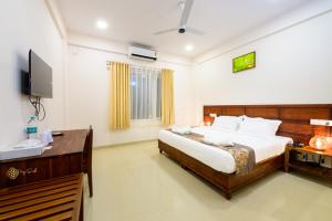 a bedroom with a large bed and a television at Daffodils Luxury Airport Suites in Angamali