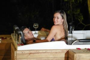 un homme et une femme assis dans une baignoire dans l'établissement Itawa Luxury Glamping & Ecoparque turísticos, à Villavicencio