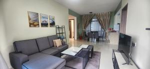 a living room with a couch and a tv at SEAVIEW FULL FURNISHED # FORESTCITY # Free WiFi in Kampong Pok Kechil