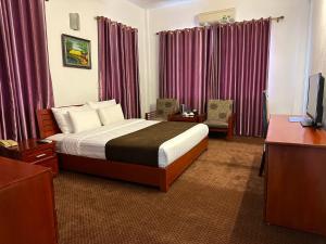 Bao Son Hotel في Ninh Lão: غرفه فندقيه سرير وتلفزيون