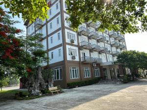 a large building with a bench in front of it at Bao Son Hotel in Ninh Lão