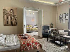 uma sala de estar com um sofá e um quarto com uma cama em Visit Debrecen Apartman em Debrecen
