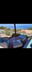 un groupe de bancs assis sur une terrasse avec la plage dans l'établissement T2 vue sur Ocean Indien, à Saint-Leu