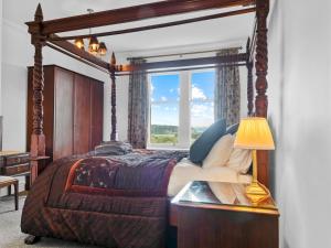 um quarto com uma cama de dossel e uma janela em Pass the Keys Olive Tree Lovely Apartment with Sea Views em Grange Over Sands