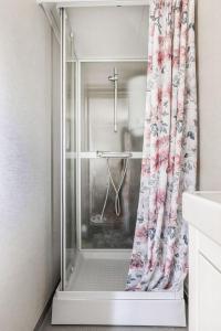 a shower with a shower curtain in a bathroom at Gulliga torpet in Vislanda