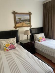 Un dormitorio con dos camas y una mesa con lámpara. en Alendo Apartments, en Johannesburgo 40 fotos más