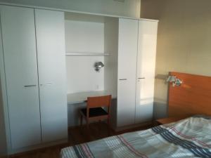 a bedroom with white cabinets and a bed and a desk at Laatuhuoneisto Saimaa näkymällä- Luxury apartment by lake Saimaa in Imatra