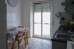 cocina con mesa, fregadero y ventana en Il nido del Cuculo, en Termoli