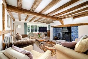 uma sala de estar com sofás e uma lareira em Walnut Tree House em Rustington