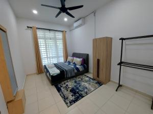 1 dormitorio con 1 cama y ventilador de techo en M2H Homestay, en Kuantan