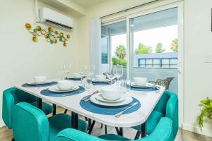 a dining room with a white table and blue chairs at 2B2B New Remodel King Bed in Altadena