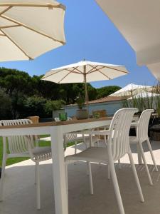 a white table with two chairs and an umbrella at Ayïa suites in Alikanas