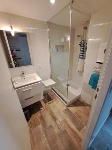 a white bathroom with a shower and a sink at Appart Madame à Chatelaillon plage 2 pers in Châtelaillon-Plage