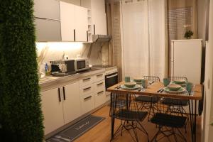 cocina con mesa, sillas y nevera en Pine Apartment Tirana, en Tirana