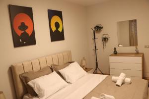 1 dormitorio con 1 cama y 2 cuadros en la pared en Pine Apartment Tirana, en Tirana