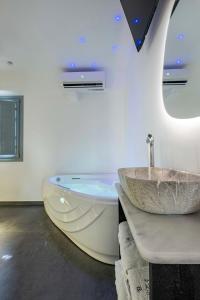 a bathroom with a sink and a bath tub at BlackStone Luxury Suites in Emporio