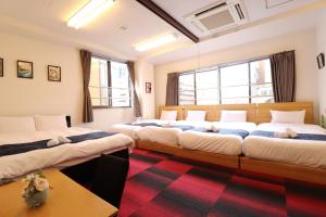 a room with three beds in it with windows at Ozawa Building in Osaka
