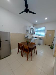 cocina con mesa y ventilador de techo en M2H Homestay, en Kuantan