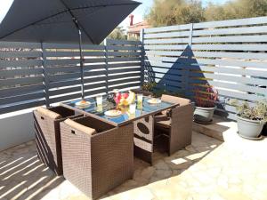 een tafel en stoelen met een parasol op een patio bij Apartment Patrik in Vabriga