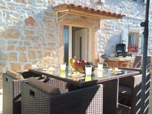 un patio con tavolo e sedie su un muro di pietra di Apartment Patrik a Vabriga