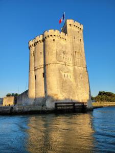 Un castillo en el agua con una bandera. en Appart Madame à Chatelaillon plage 2 pers, en Châtelaillon-Plage