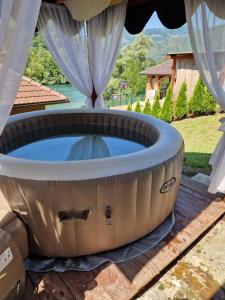 a large hot tub sitting on a deck with a window at Brvnara Maljkovic Drina 