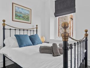 格兰奇奥沃桑茨Pass the Keys Mulberry Beautiful Apartment with Sea View的一间卧室配有带白色床单和蓝色枕头的床。