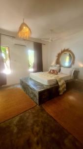 a bedroom with a large bed and a mirror at Garden Beach Bungalows Jambiani in Jambiani