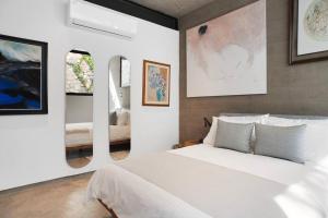 1 dormitorio con 1 cama blanca y 2 espejos en Casa Galería Blackaller, en La Paz 42 fotos más