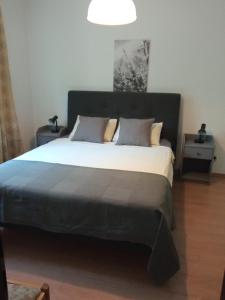 a bedroom with a large bed with a black headboard at Beautiful location apartment in Sofia