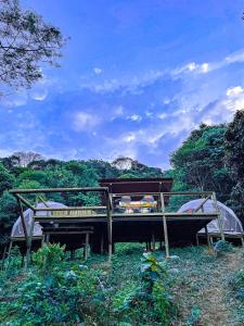 uma cama no meio de um campo com árvores em Glamping Itawa & Ecoparque turístico em Villavicencio