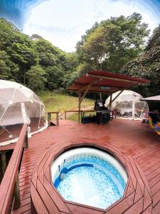 比亞維森西奧的住宿－Glamping Itawa & Ecoparque turístico，甲板上的热水浴池配有2把遮阳伞