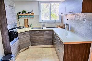 a kitchen with wooden cabinets and a sink and a window at זמן מדבר in Mitzpe Ramon