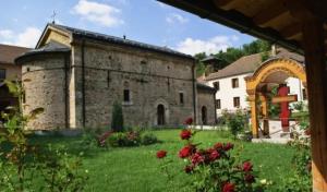 a large stone building with a yard with flowers at Bagins Apartman in Kostolac