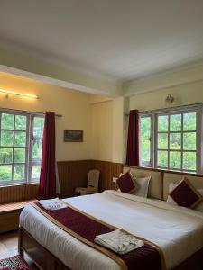 sypialnia z dużym łóżkiem z czerwonymi zasłonami w obiekcie Ifseen Villa w mieście Pelling