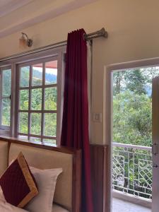 1 dormitorio con 1 cama, 2 ventanas y balcón en Ifseen Villa en Pelling
