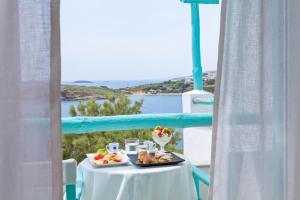 una mesa con una bandeja de comida en el balcón en Paradise Design Apartments, en Batsi