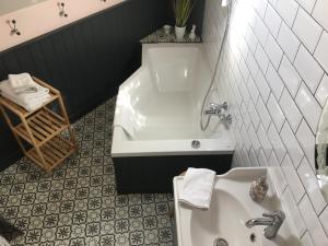 La salle de bains est pourvue d'une baignoire et d'un lavabo. dans l'établissement Bed and Breakfast à Rochefort-en-Terre, à Rochefort-en-Terre