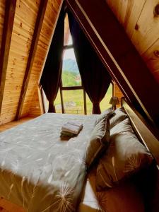 duże łóżko w pokoju z oknem w obiekcie LUX VILA MOTICKI GAJ w mieście Žabljak