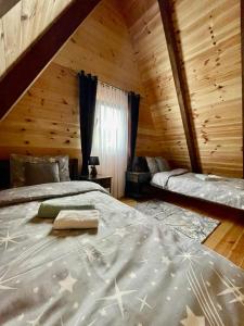 sypialnia z 2 łóżkami w drewnianym domku w obiekcie LUX VILA MOTICKI GAJ w mieście Žabljak