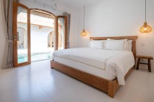 um quarto com uma cama grande e uma janela grande em Tamary's Villa 3 BR in Ungasan em Ungasan