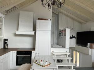 een keuken met een witte koelkast en een tafel bij Les coeurs brisés in Crans-Montana