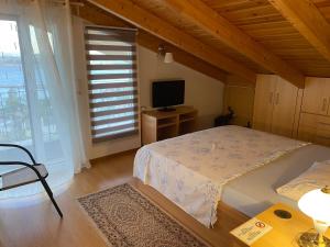 um quarto com uma cama grande e uma televisão em Siga Siga Apartment em Mégara