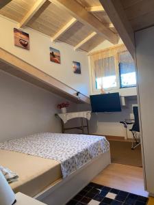 um pequeno quarto com uma cama e uma secretária em Siga Siga Apartment em Mégara